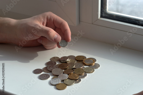 A man counts money and divides it. Round coins. 