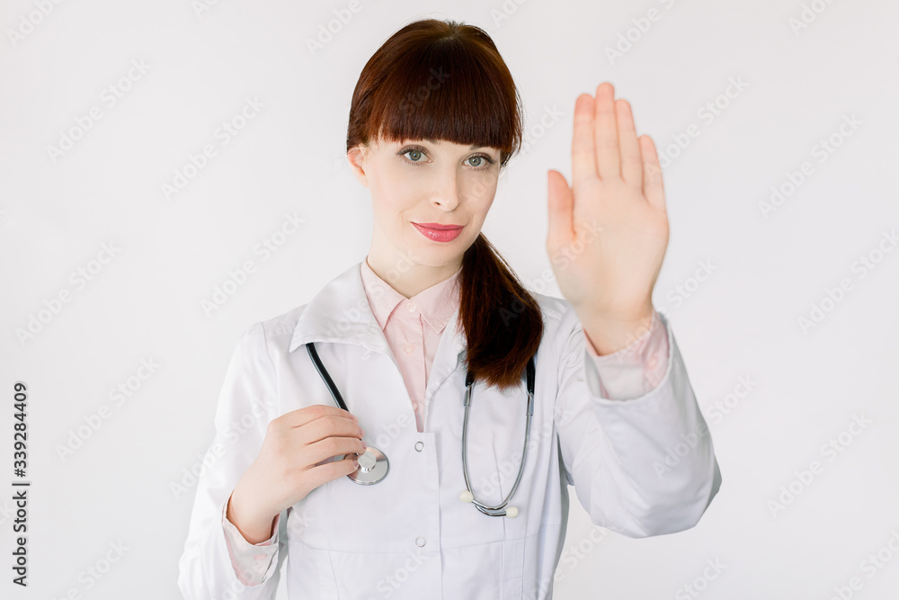 Young female GP doctor gesturing stop Coronavirus disease, COVID-19, 2019-ncov, global pandemic outbreak, standing over white background. Not spread virus worldwide, stay safe at home concept Young female GP doctor gesturing stop Coronavirus disease, COVID-19, 2019-ncov, global pandemic outbreak, standing over white background. Not spread virus worldwide, stay safe at home concept