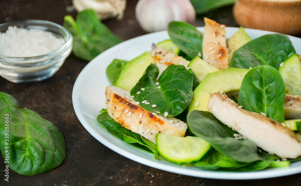 Grilled chicken breast with avocado and herbs on a dark background. Dietary nutrition. Healthy lifestyle. Side view. Close-up.