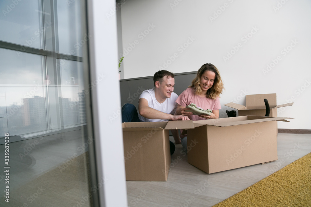 home, people, moving and real estate concept - happy couple having fun at new home. home, people, moving and real estate concept - happy couple having fun at new home.