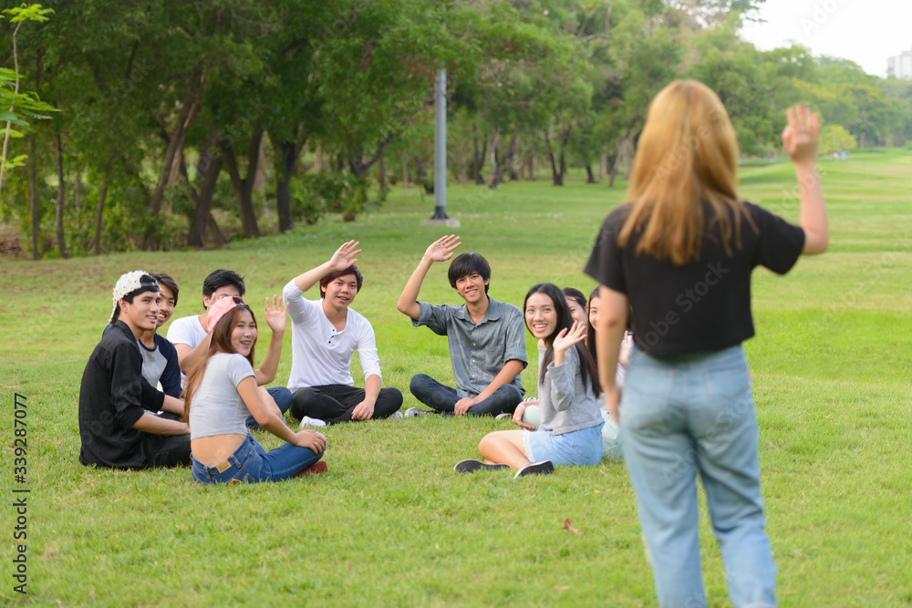 Happy young group of friends greeting together at the park Happy young group of friends greeting together at the park