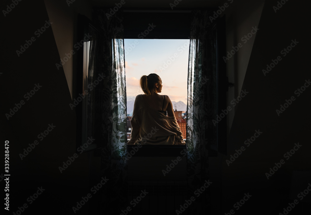 Woman sitting on a windowsill.