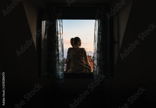 Woman sitting on a windowsill.