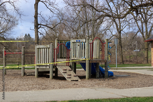 Caution tape surrounds a playground closed due to the COVID-19 pandemic at a city park 