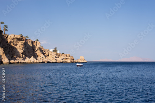 Sharm el Sheikh red sea coastline. High cliffs and a motorboat in the sea.