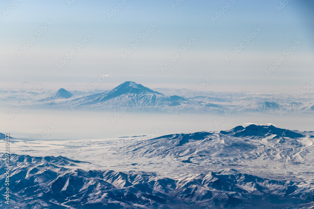 Mount Ararat over the clouds. 
A view from the plane window.