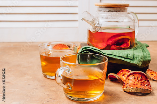 Bael fruit juice or quince tea and dried bael sliced fruit on rustic background. Thai or Asian healthy drink. Bael is helping the body to resist catching a cold.