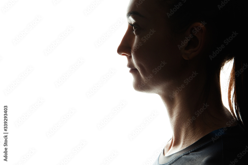 Silhouette of a white sports woman on a white background. Look with a side. The portrait isolated. Close up.