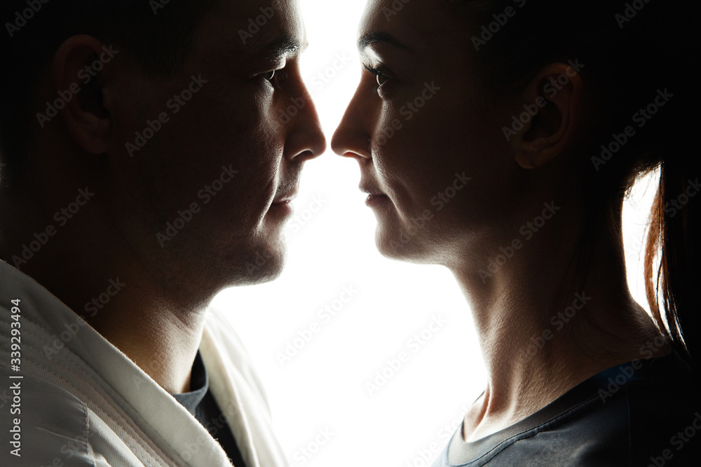 Silhouettes of a white sports woman and a white man in profile, look at each other against an isolated background. Concept of sport Silhouettes of a white sports woman and a white man in profile, look at each other against an isolated background. Concept of sport