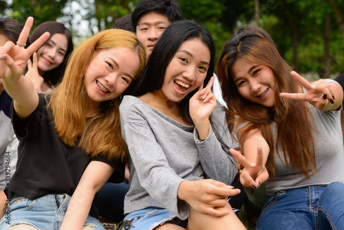 Happy young group of friends having fun together at the park