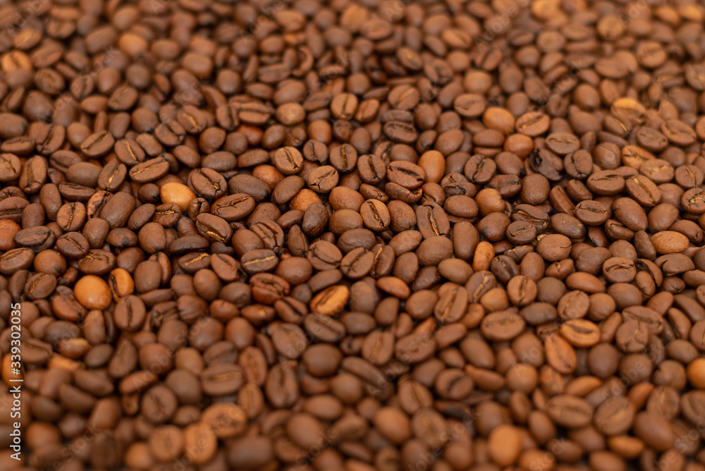 Roasted coffee beans as a background. Coffee beans creative background for advertising. Coffee beans texture. Small depth of field. Roasted coffee beans as a background. Coffee beans creative background for advertising. Coffee beans texture. Small depth of field.