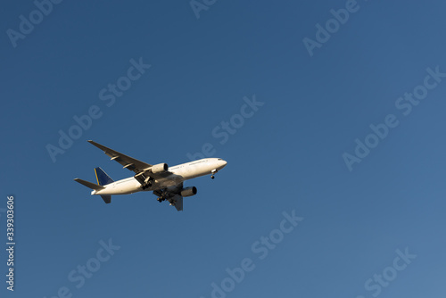 White plane is preparing for landing. White plane in the blue sky.