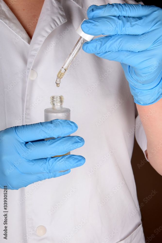 dropper in the hands of a nurse in blue rubber gloves dropper in the hands of a nurse in blue rubber gloves