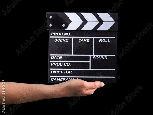 Human hand holding film clapper board isolated on black background photo