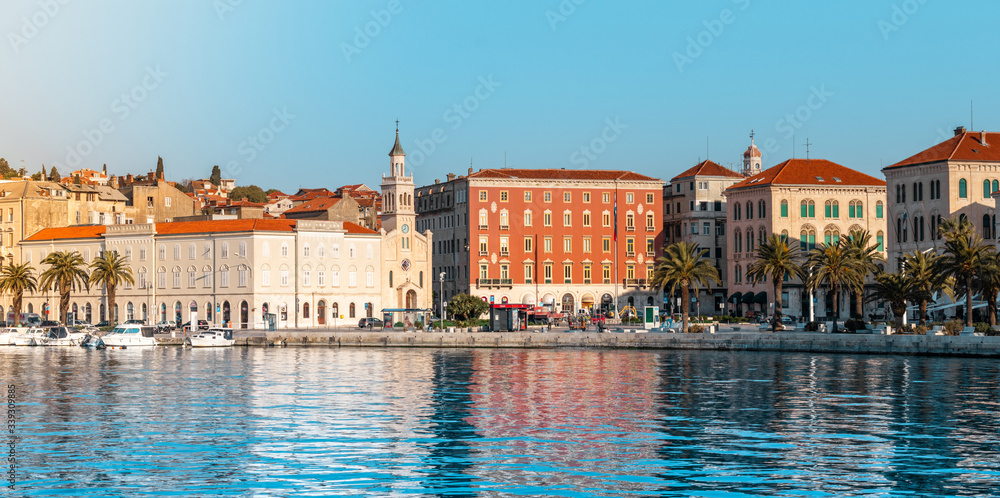 Beautiful view of the seaside part, riviera promenade of Split, Croatia. Bright blue sea with palms and old church buildings along the 