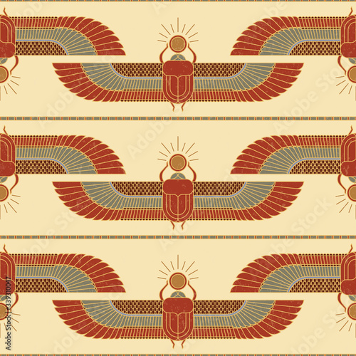 Symbols of ancient Egypt in the form of a nonsense pattern with an illustration of a scarab beetle with a sun symbol in its paws and wings.