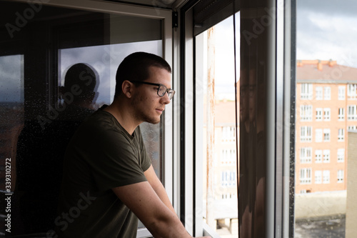 quarantined man looking out the window