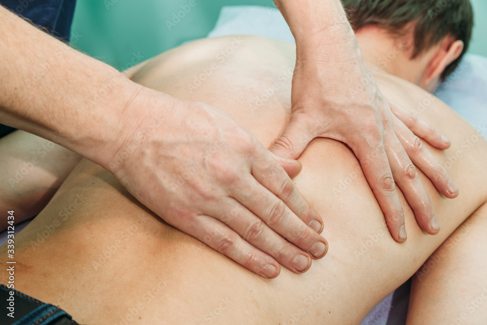 physiotherapist doing back massage to her patient in medical office physiotherapist doing back massage to her patient in medical office