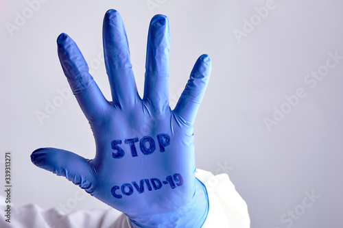 hand medical rubber glove with the inscription stop covid19