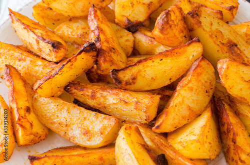 Golden spicy potato wedges fried or oven baked closeup.