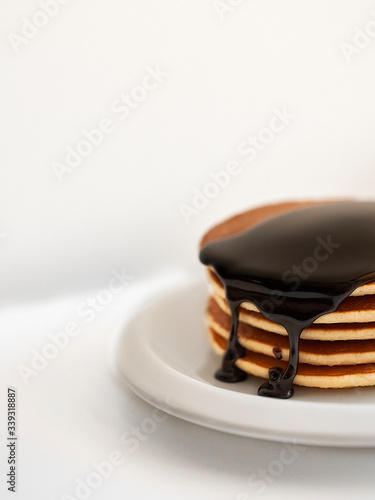 pancakes with dressing chocolate on white plate on white background