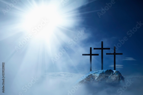 Photographie Silhouette of three crosses on a rocky hill against dramatic sky background and symbolize the Crucifixion and resurrection of Jesus Christ