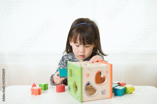 toddler girl playing number shape blocks for homeschooling