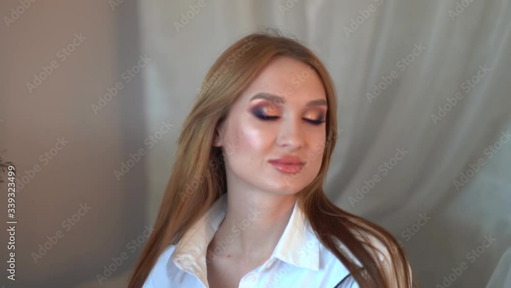 The girl after applying makeup poses in front of the camera. The girl after applying makeup poses in front of the camera.