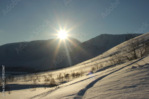  the sun sets behind snow-covered mountains