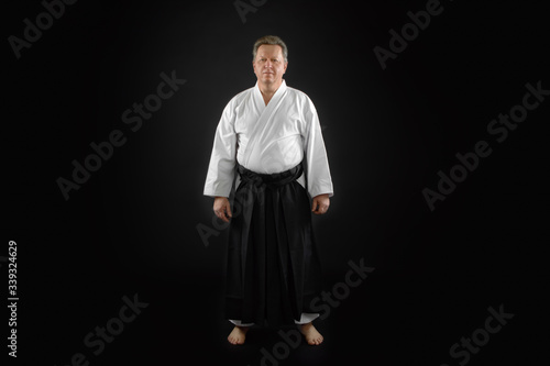 Portrait aikido master wearing traditional samurai hakama clothes. on black Background photo