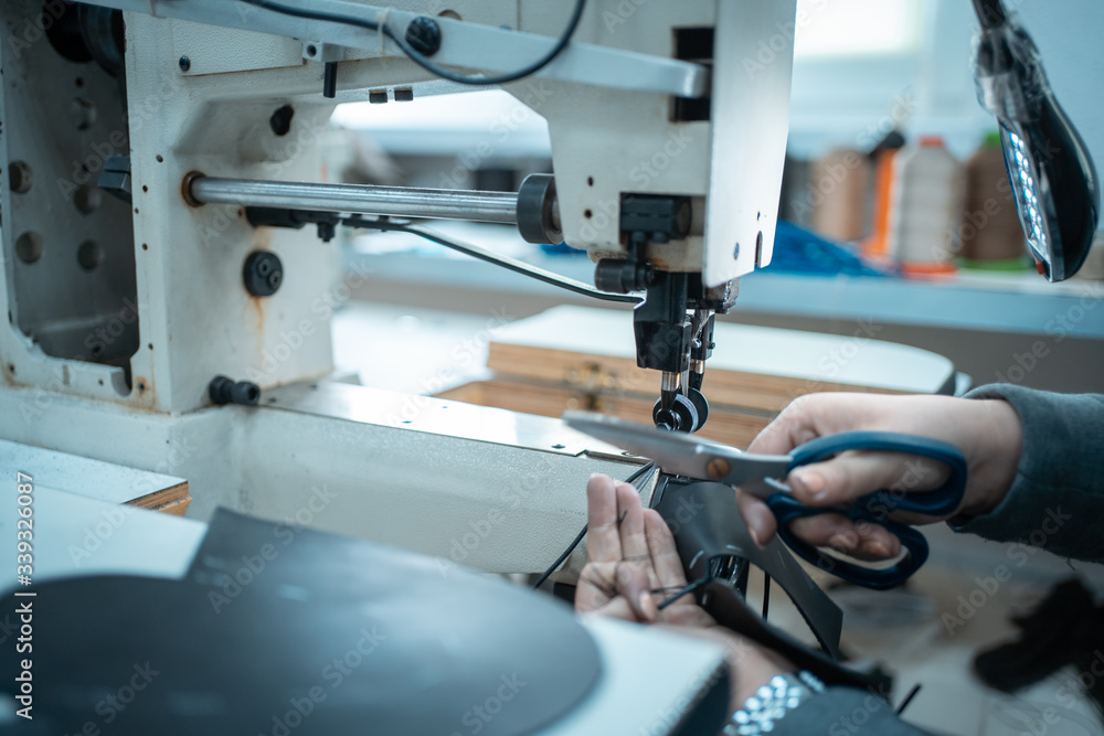 Fototapeta premium woman work with sewing machinery on shoe factory