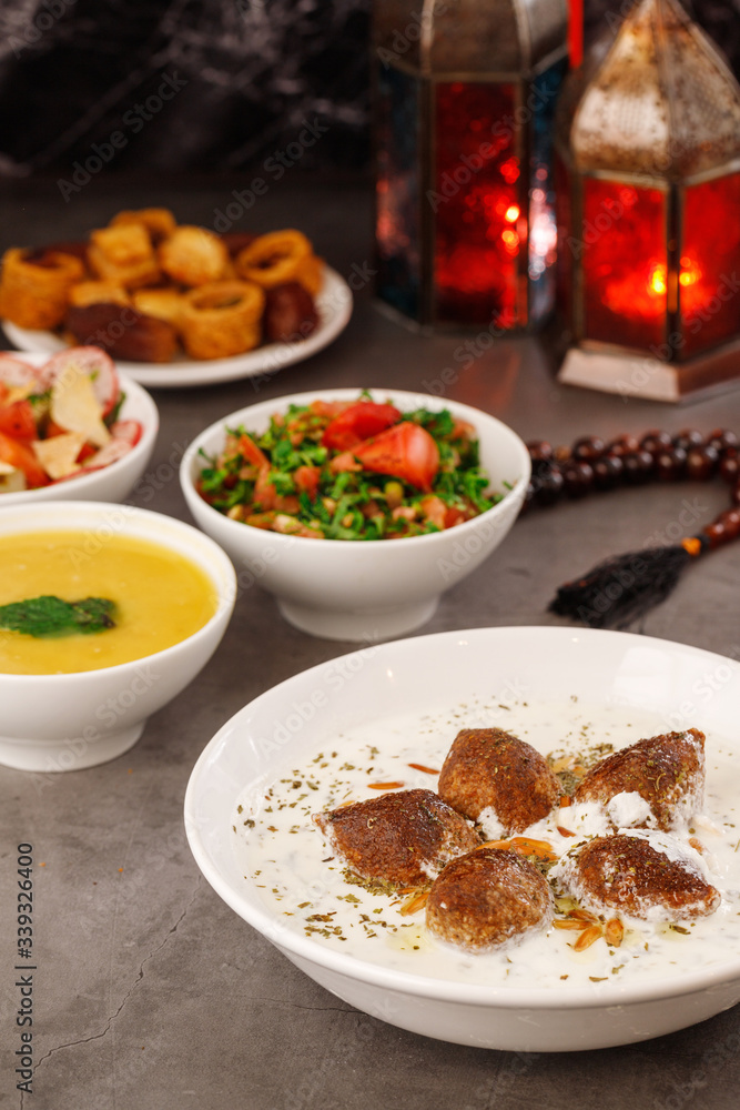 Fototapeta premium Ramadan. Arabic family dinner. Traditional arabic food. Close-up view. Eid Mubarak. Table with sharing plates food. Ramadan decoration. Lebanese cuisine. Starters, hummus, baklava, dates. Muslim