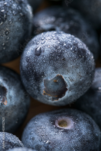 Fresh blueberry in white plate photographed against wooden background