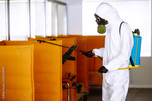 Disinfecting of office to prevent COVID-19, Man in protective hazmat suit with with spray chemicals to preventing the spread of coronavirus, pandemic in quarantine city. Cleaning concept.