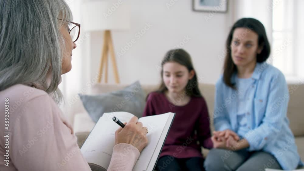 Sad and depressed small girl, mother and therapist indoors, mental health concept. Sad and depressed small girl, mother and therapist indoors, mental health concept.
