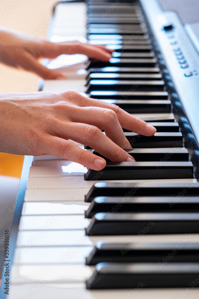 hands playing piano at home. Close-up