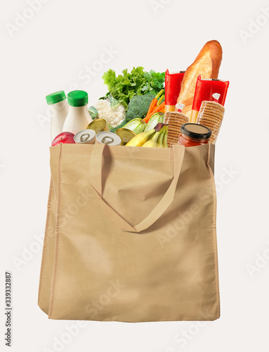 Eco-friendly reusable shopping bag filled with different goods on a white background photo