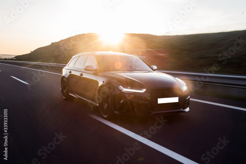 Εκτύπωση καμβά Driving black car under the sunlights