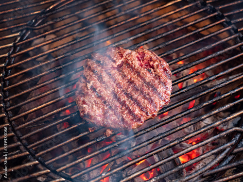Closeup picture of a single burger patty on the grill