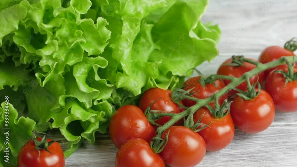 Lettuce salad and tomatoes on a grey wooden table Lettuce salad and tomatoes on a grey wooden table