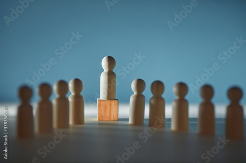 Wooden figures of people on shades background. Leader miniature on cube, copy space. Shadow economy mockup template