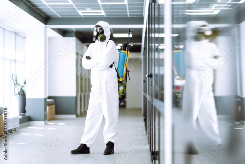 Man in protective hazmat suit in an empty office. Concepts to preventing the spread of coronavirus, pandemic in quarantine city. Covid -19. © maxbelchenko