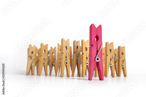 Clothespins simulating a woman standing out from a group of people.