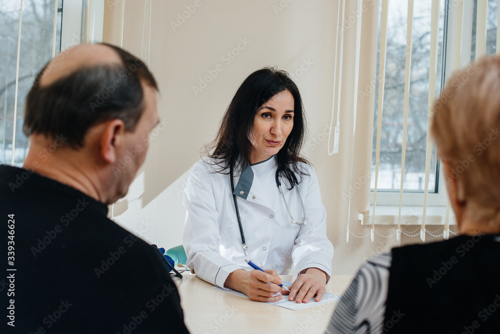 A couple of elderly people at a personal doctor's appointment at a medical center. Medicine and healthcare A couple of elderly people at a personal doctor's appointment at a medical center. Medicine and healthcare