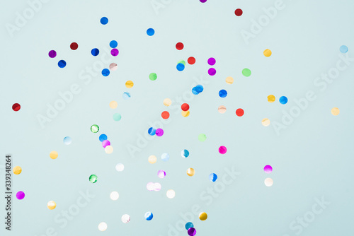Confetti scattered on the light blue background. Bright dots on the background