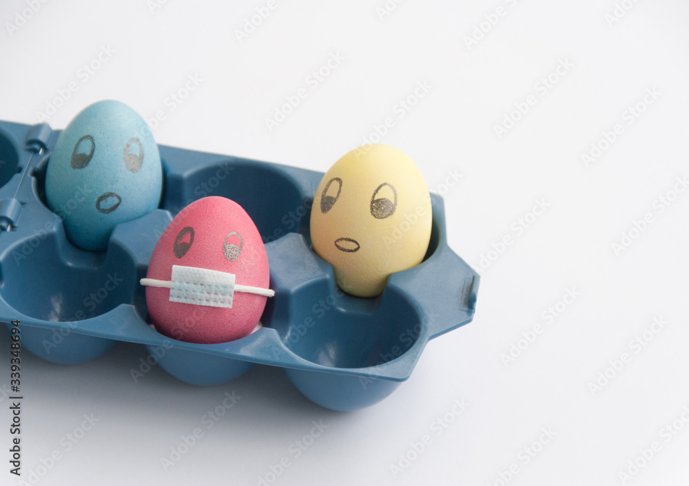 Close up view of pink chicken egg with face with drawn medical face mask among other eggs without. Easter egg during coronavirus outbreak concept Close up view of pink chicken egg with face with drawn medical face mask among other eggs without. Easter egg during coronavirus outbreak concept