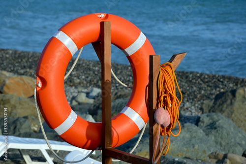 orange life buoy on the beach by the sea
