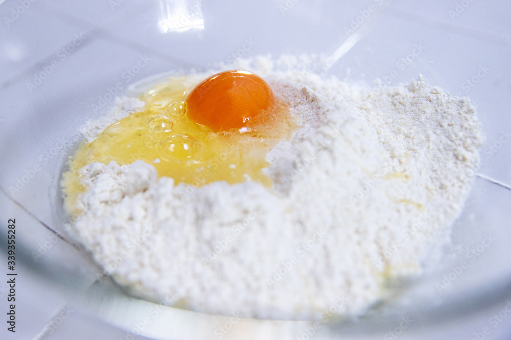 raw egg on pile of flour ingredients for pancake recipe raw egg on pile of flour ingredients for pancake recipe