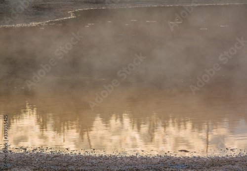 Fototapeta Naklejka Na Ścianę i Meble -  Early Morning Reflections In Chromatic Pool, Upper Geyser Basin, Yellowstone National Park, Wyoming, USA
