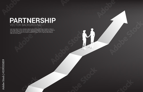 Silhouette of businessman handshake on growing graph. Concept of team work partnership and cooperation.